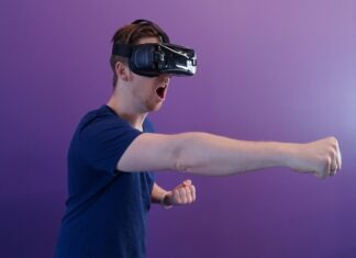 Exploring Virtual Reality (VR) Casinos: The Future of Gambling? Man Punching in the Air while in VR Goggles