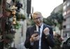 Avoid These Golden Slipper Betting Pitfalls for Smarter Wagers Excited young man in formal wear and eyeglasses clenching fist and rejoicing victory while using mobile phone in modern city street