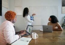 The Latest Microsoft Teams Updates in April 2022 Three people in an office working with their Microsoft laptops