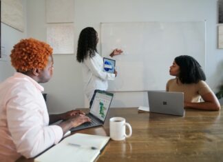 The Latest Microsoft Teams Updates in April 2022 Three people in an office working with their Microsoft laptops