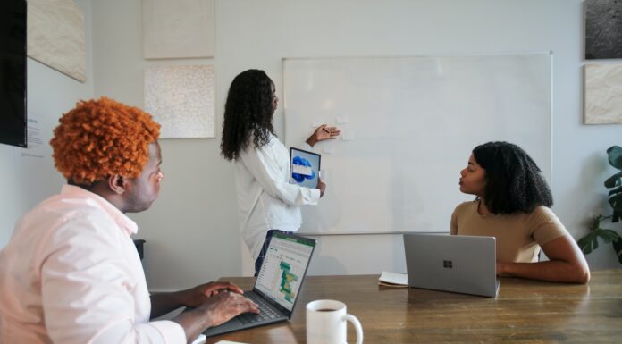 The Latest Microsoft Teams Updates in April 2022 Three people in an office working with their Microsoft laptops
