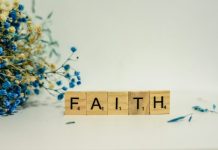 The Role of Faith in Coping with Life’s Difficulties a wooden block that says faith next to blue flowers