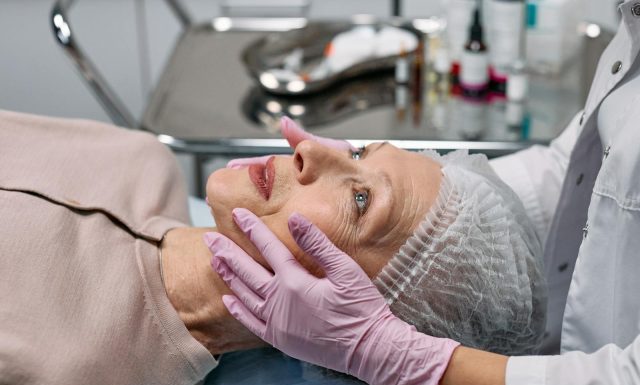 Belleza y Armonía: Tratamientos Estéticos para Potenciar tu Imagen Medical professional examining a senior woman's face in a clinical setting.