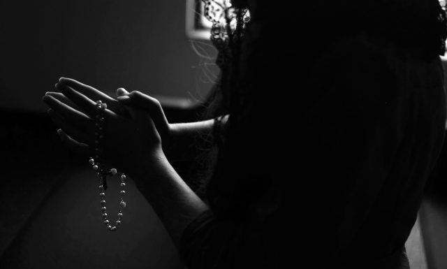 The Saving Power of Religion and its Positive Effects on Mental Health silhouette of woman holding rosary while praying