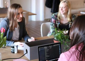 How Headless CMS Facilitates Real-Time Collaboration for Content Teams a group of women sitting around a wooden table