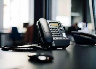 AI vs. Human Cold Calls: What Works, What Doesn’t, and What’s Next black ip desk phone on black wooden table