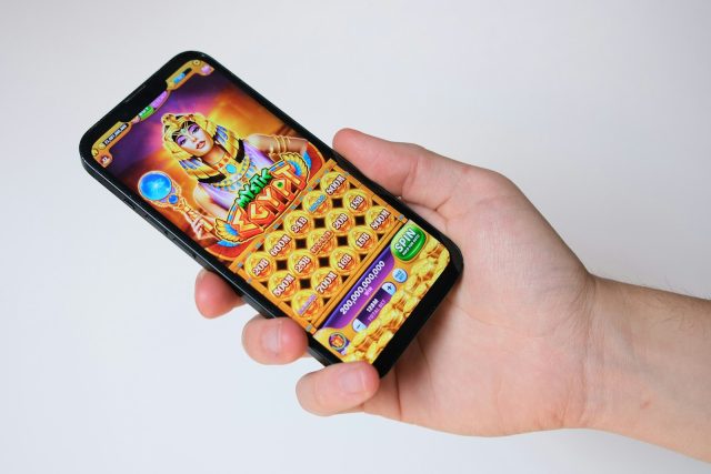 Photo by Niek Doup A hand holds a phone with an egyptian-themed game.