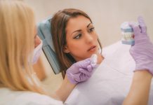 7 Secrets Your Dentist Will Never Tell You Patient of a dentist looking at fake teeth