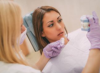 7 Secrets Your Dentist Will Never Tell You Patient of a dentist looking at fake teeth