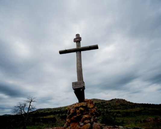 The Best Catholic Travel Destinations brown wooden cross on brown rock under white clouds during daytime