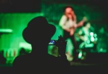 Boosting Your Band’s Brand: The Power of Quality Merchandise silhouette of man holding camcorder near woman singing on stage