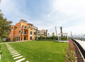 Wellness-Centric Luxury Property in Dubai: Homes Built for Mind & Body A luxurious building sits beside a vibrant green lawn.