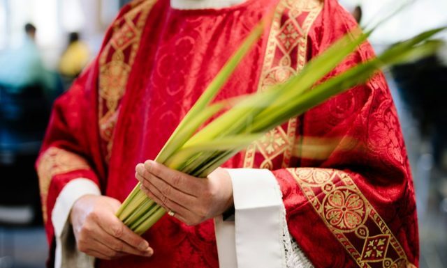 Celebrating Holy Week Around the World: A Time of Reflection, Tradition, and Devotion priest holding palm leaves
