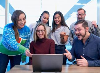 Trending Courses to Study Abroad After 12th: Admission Routes and Career Prospects men and women sitting and standing while staring at laptop