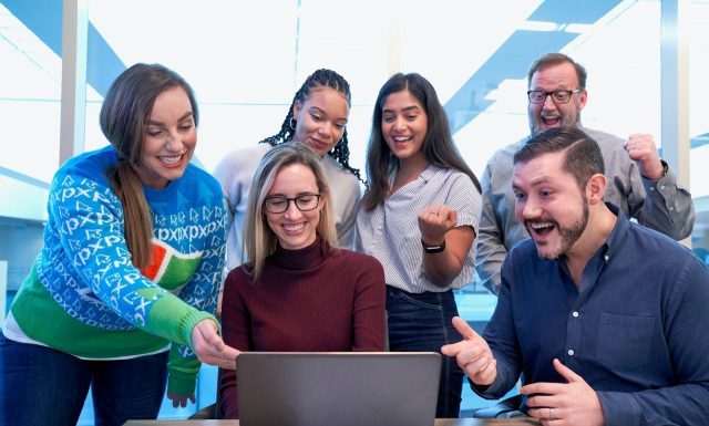 Trending Courses to Study Abroad After 12th: Admission Routes and Career Prospects men and women sitting and standing while staring at laptop