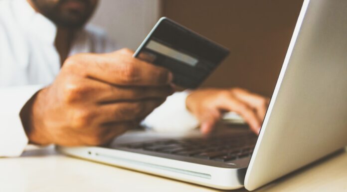 Promotion Strategy for eCommerce Businesses person using laptop computer holding card