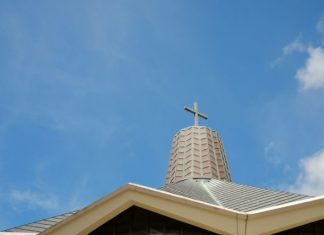 A Veteran’s Encounter with Divine Joy: Faith Lessons from a Near-Death Experience white concrete cross on top of roof under blue sky during daytime