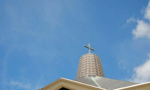 A Veteran’s Encounter with Divine Joy: Faith Lessons from a Near-Death Experience white concrete cross on top of roof under blue sky during daytime