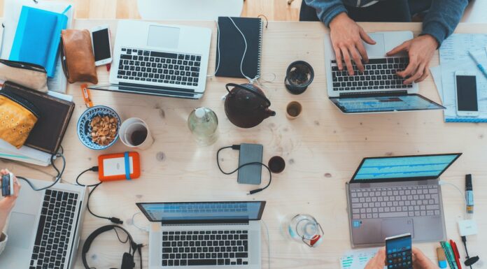 Speeding Up Web and App Development with No Code Solutions people sitting down near table with assorted laptop computers