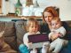 Crucial Factors to put in Mind When Buying a Home with Kids two babies and woman sitting on sofa while holding baby and watching on tablet