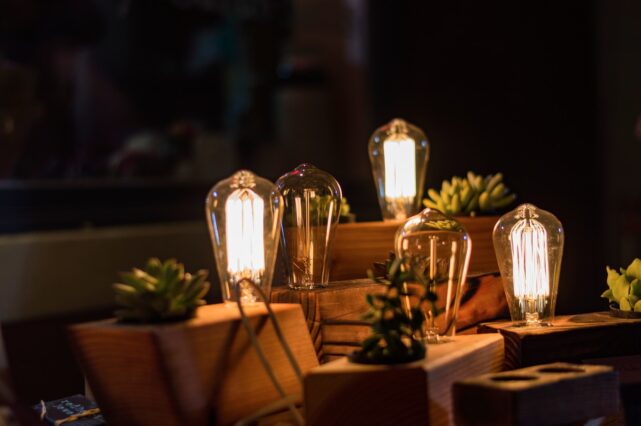 closeup photo of three lighted table lamps with plants
