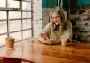 Stranger to Friend – Why OmeTV is the Best Social App a woman sitting at a table looking at her phone