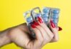 Viagra/Sildenafil: Rediscovering Intimacy and Connection a woman's hand holding two contraptions in front of a yellow background